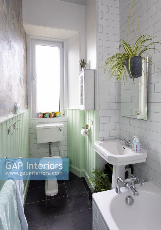 Salle de bain blanche avec boiseries peintes en vert menthe