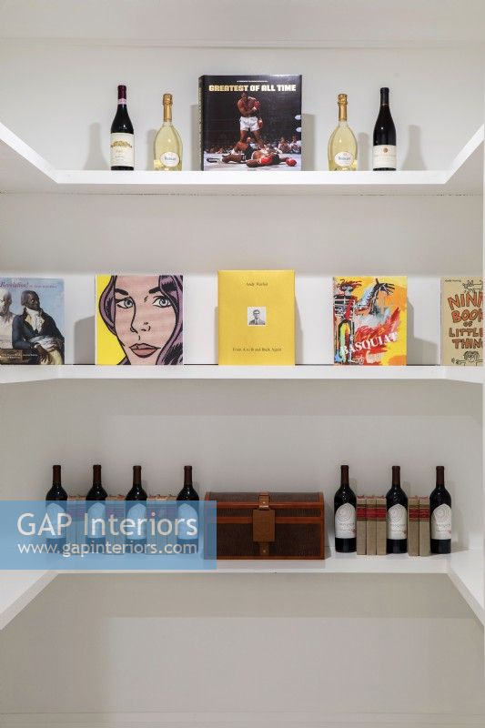 Étagères blanches avec affichage du vin et des livres