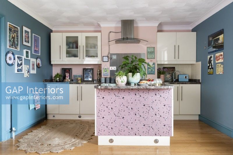 Vue dans la cuisine moderne avec des unités blanches et des murs bleus et roses