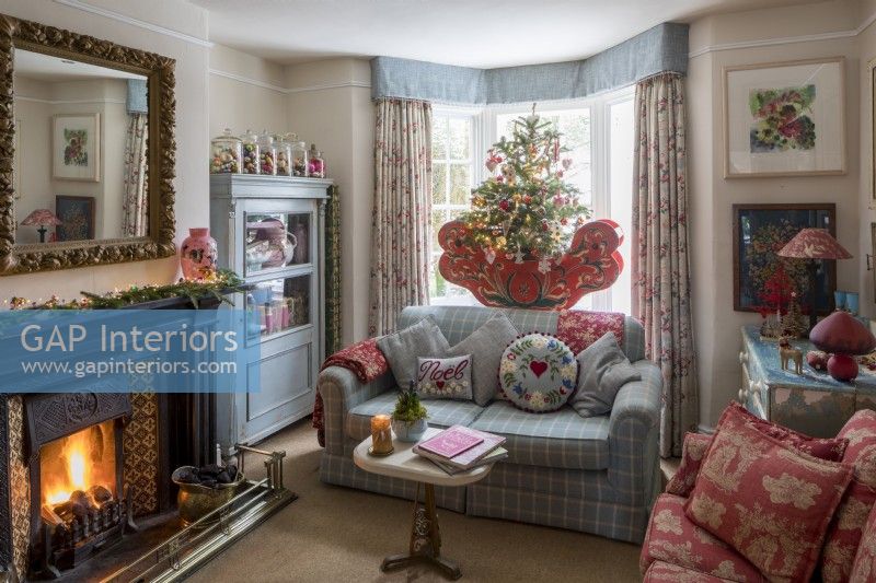 Salon avec canapé confortable et cheminée, décoré pour Noël