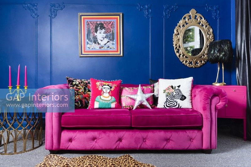 Canapé rose contre un mur bleu du salon