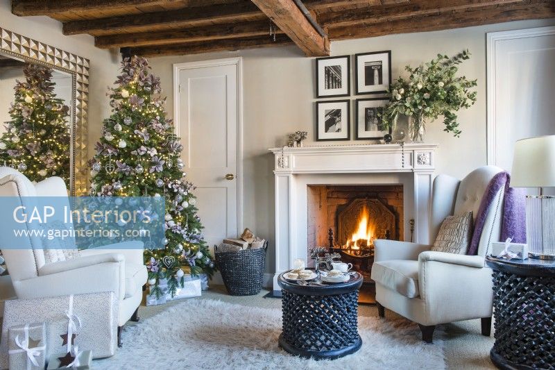 Cheminée allumée dans un confortable salon classique décoré pour Noël