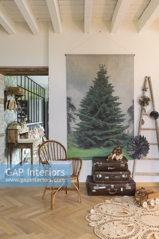 Vieilles valises et peinture d'arbre de Noël dans le salon de pays