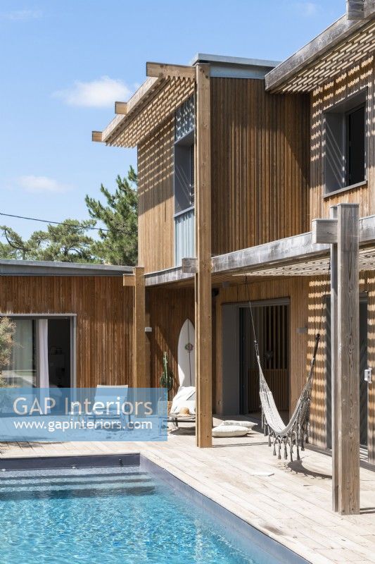Maison en bois moderne avec piscine et coin salon en terrasse