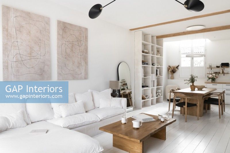 Espace de vie moderne décloisonné peint en blanc avec des meubles en bois