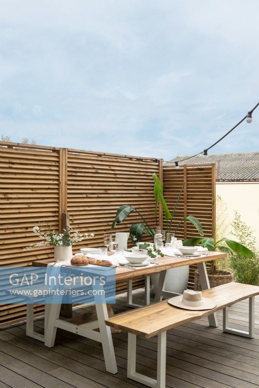 Table de pique-nique moderne sur terrasse avec écran de protection de la vie privée