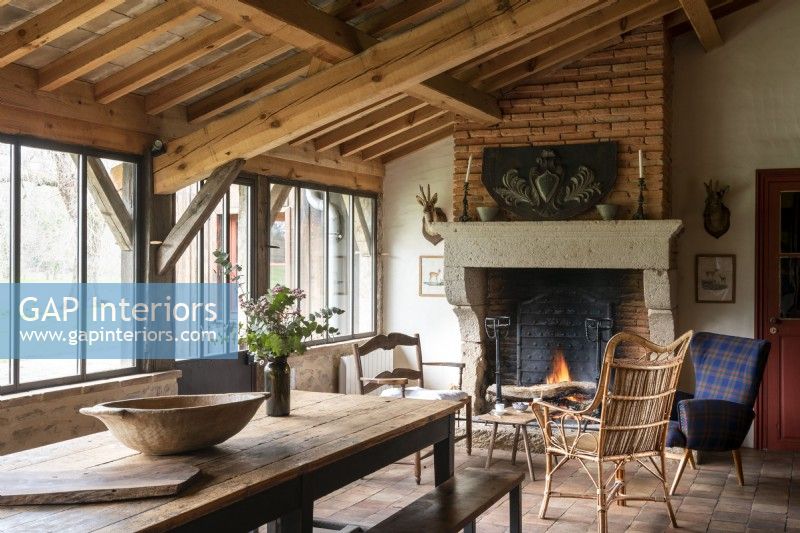 Table en bois rustique en pays salle à manger avec cheminée allumée