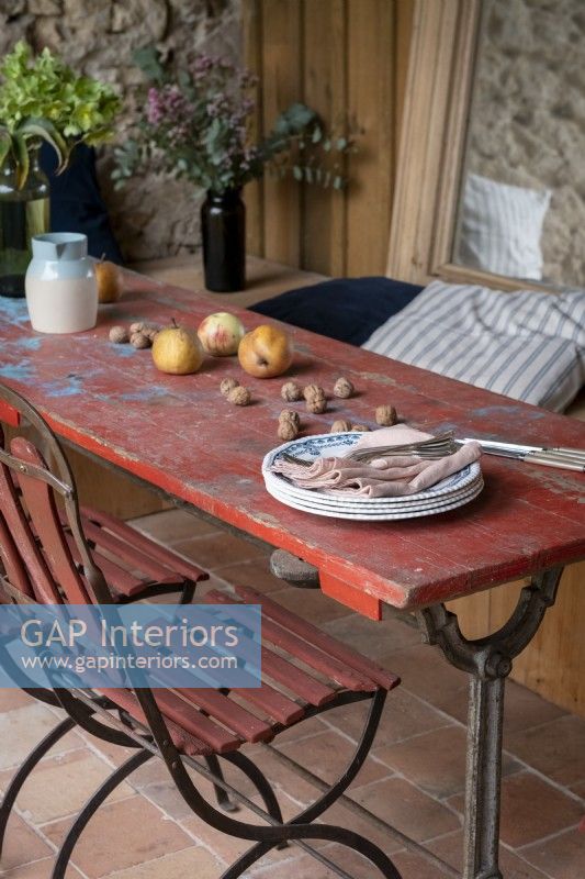 Détail de la table à manger extérieure en bois rouge en détresse sur la terrasse