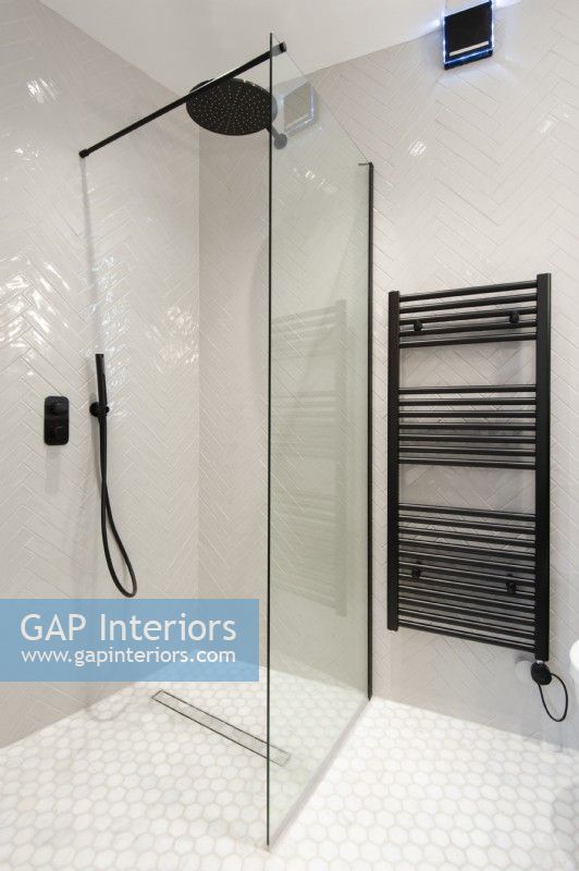 Douche à l'italienne moderne carrelée avec radiateur sèche-serviettes noir