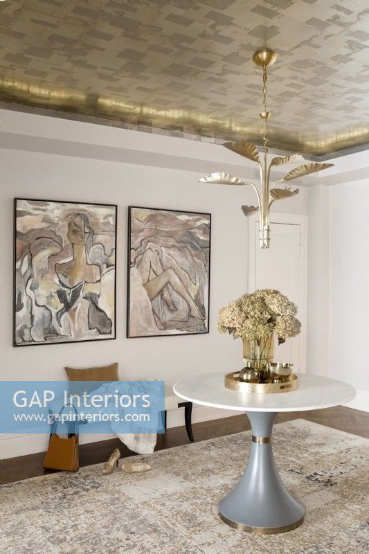 Détails de la chambre avec papier peint en feuilles de métal au plafond décoré d'un guéridon, d'un banc et d'œuvres d'art.