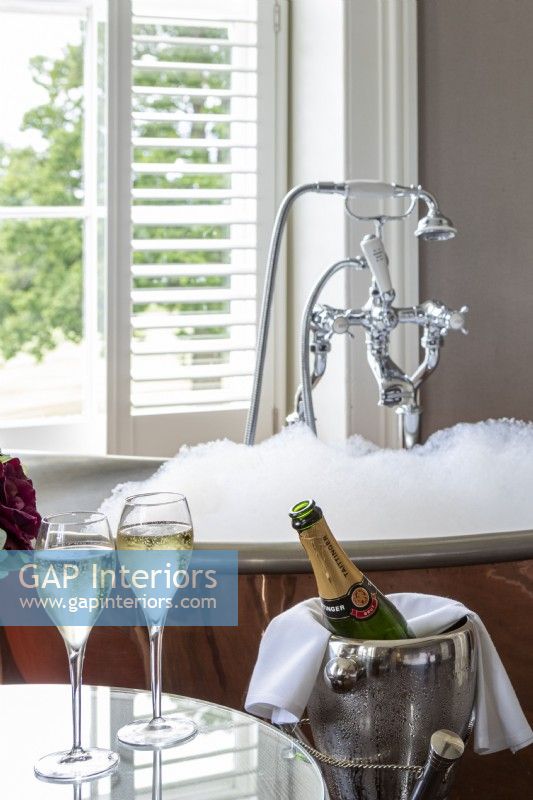 Salle de bain luxueuse, avec bain moussant et champagne servi