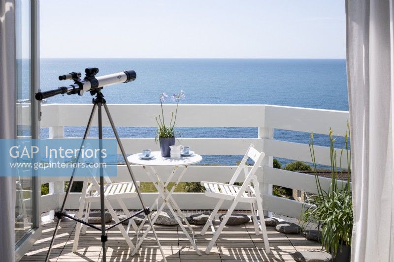 Télescope donnant sur la mer, balcon peint en blanc.
