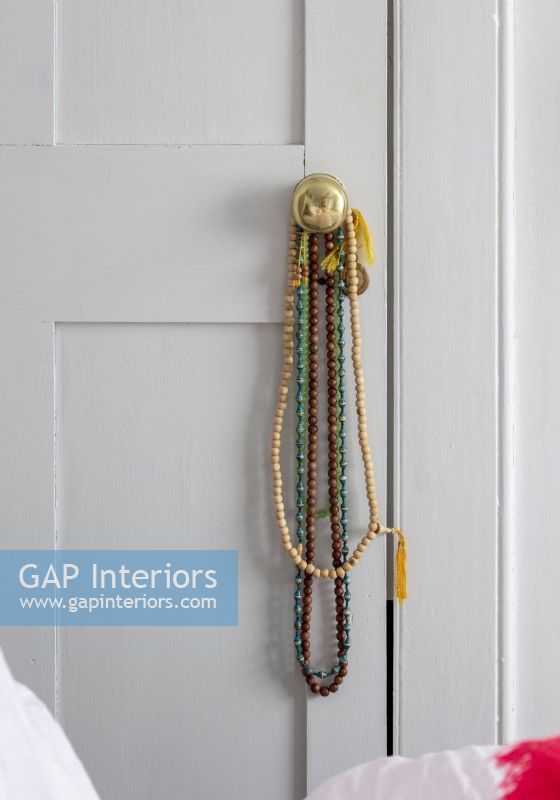 Détail des colliers de perles sur la poignée de porte