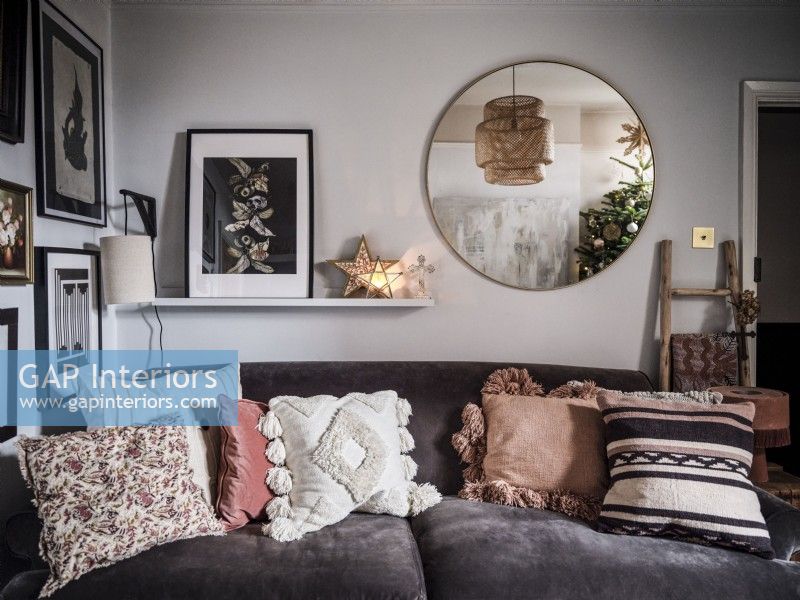 Petit salon avec canapé en velours, étagère et photos