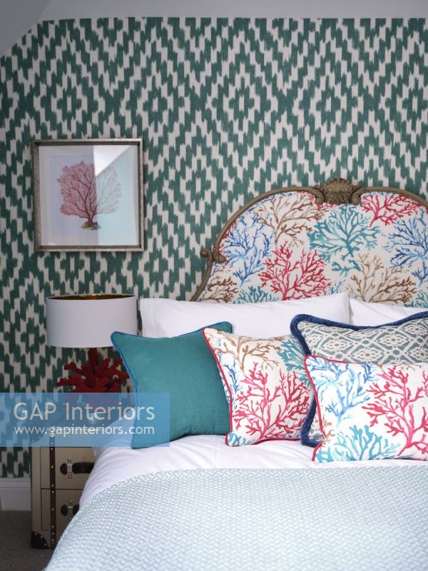 Chambre colorée d'inspiration côtière avec tête de lit rembourrée et papier peint