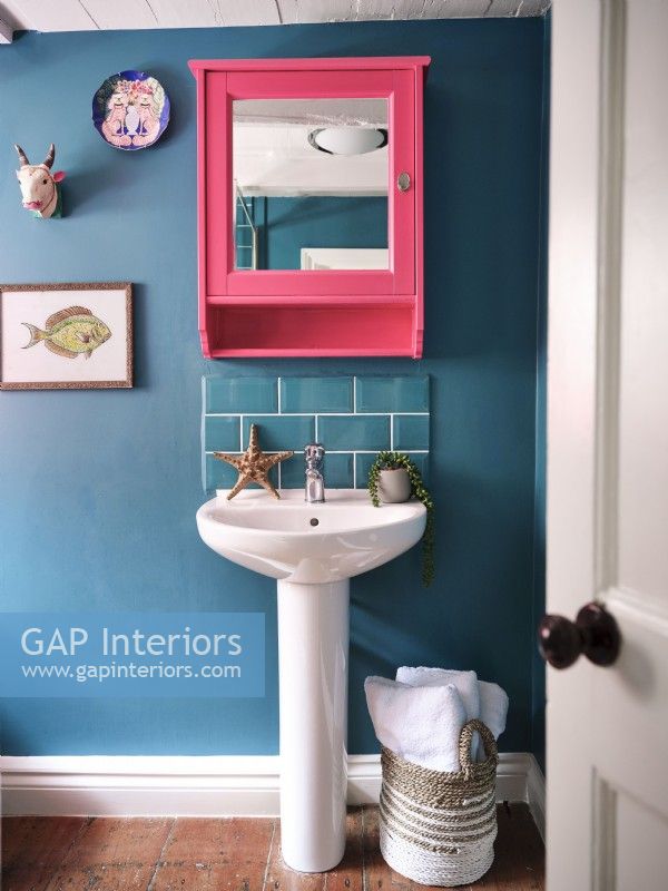 Lavabo de la salle de bain bleue avec miroir rose