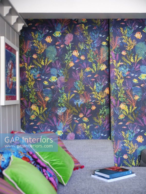 Mur inspiré de la mer et coussins colorés sur un canapé gris