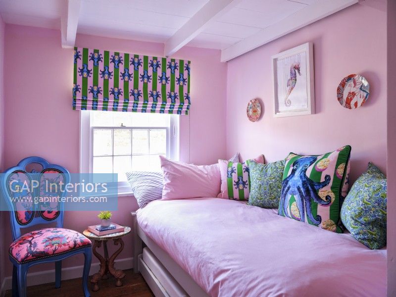 Chambre rose avec chaise rembourrée, tissus d'ameublement côtiers et œuvres d'art