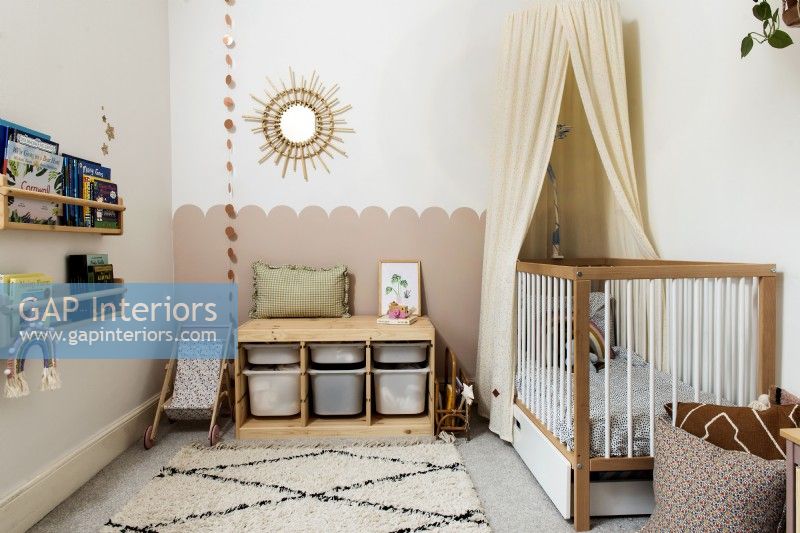 Chambre de bébé avec lit bébé et banquette de rangement en bois
