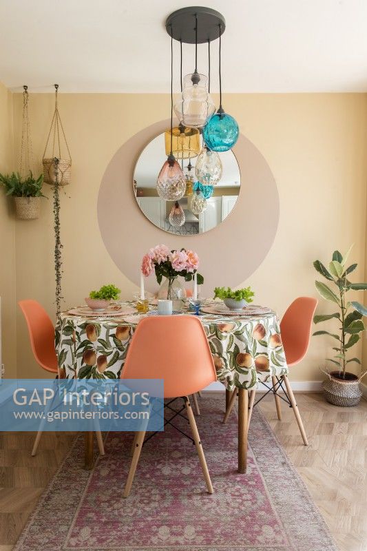 Chaises orange autour d'une petite table à manger avec nappe rétro