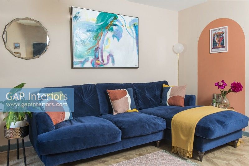 Grand canapé bleu foncé dans le salon aux murs peints