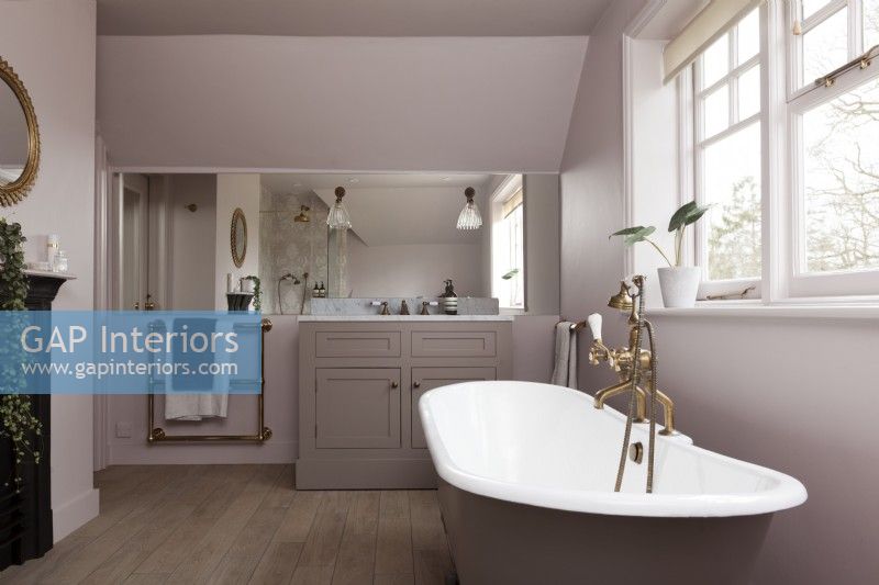 Salle de bain familiale classique avec baignoire sur pieds, lavabo encastré en marbre, robinets en laiton et douche