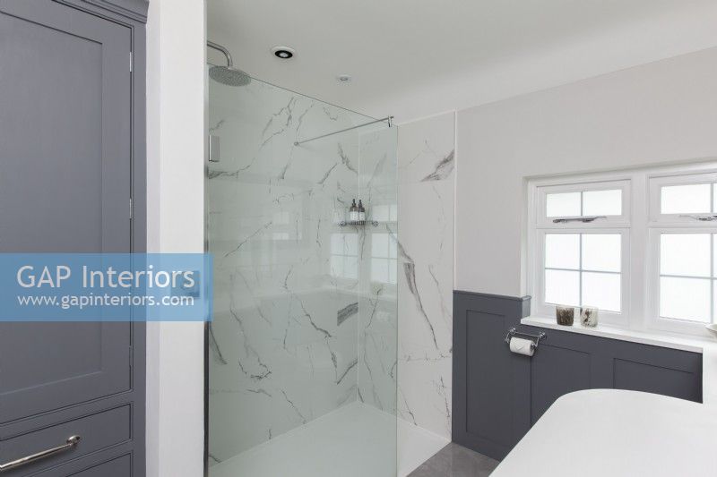 Salle de douche classique avec panneaux gris et carreaux de marbre