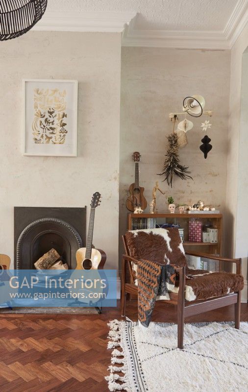 Vue d'une cheminée dans un salon avec des meubles et accessoires vintage éclectiques.