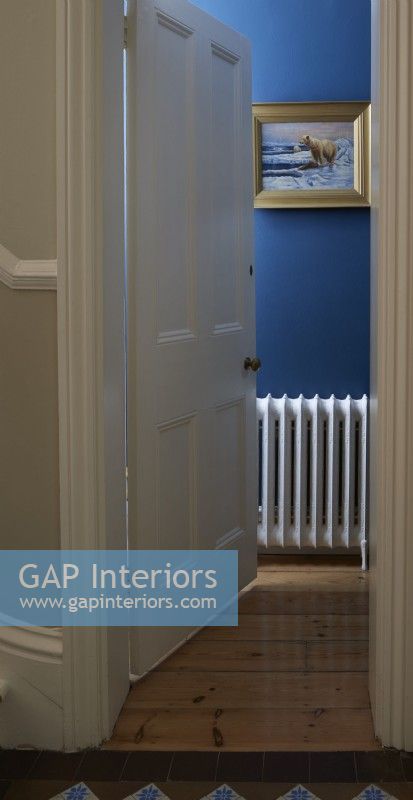 Par une porte dans un vestiaire peint en bleu montrant un radiateur blanc