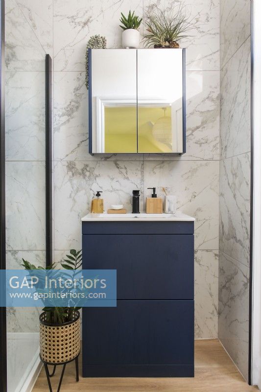 Évier moderne et miroir dans la salle de bain avec carrelage mural en marbre
