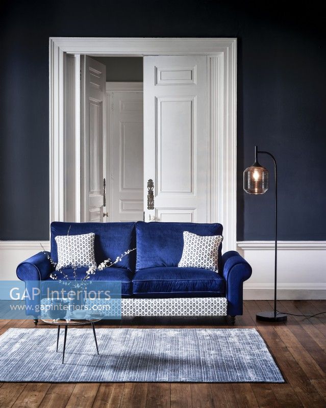 Canapé bleu moderne dans une chambre bleue avec tapis et lampe