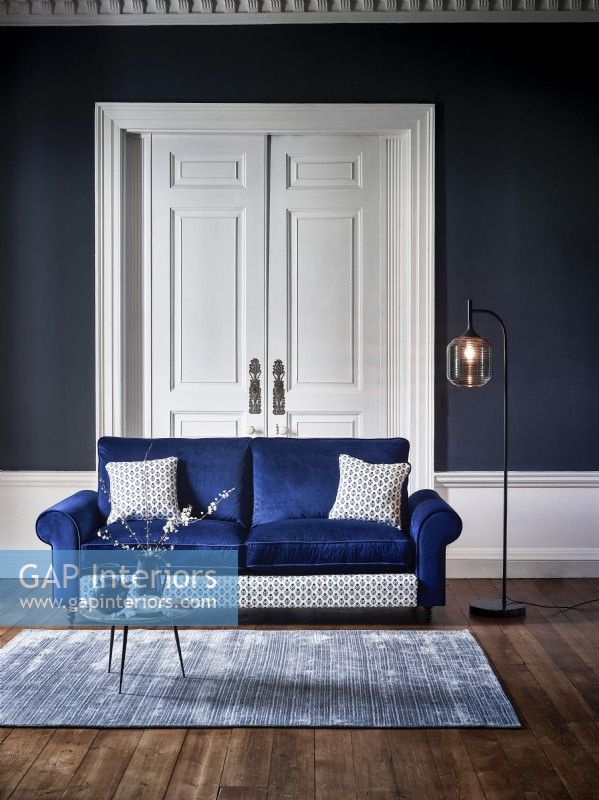 Canapé bleu moderne dans une chambre bleue avec tapis et lampadaire