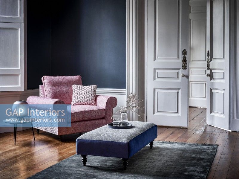 Chaise rose dans la chambre bleue avec tapis