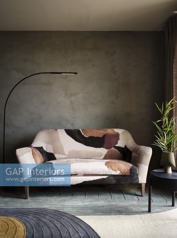 Canapé à motifs devant un mur de béton texturé