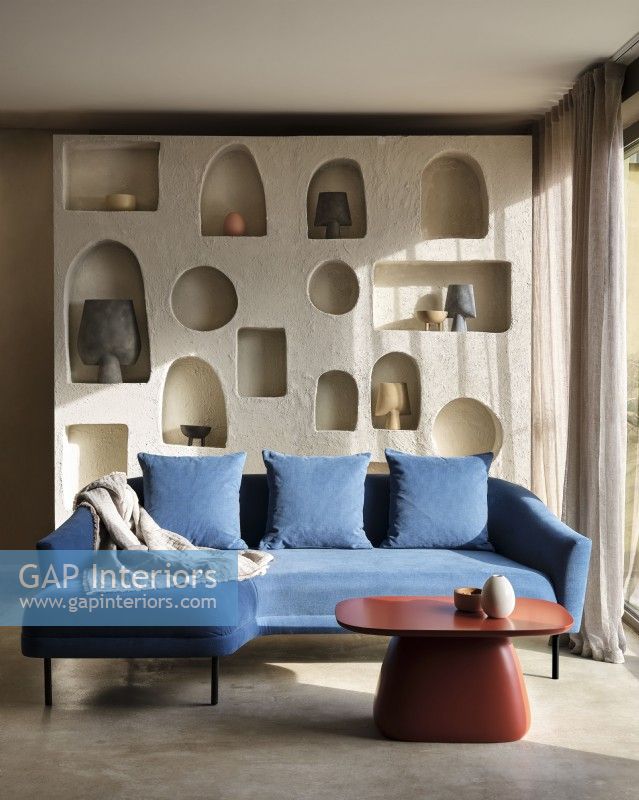 Canapé d'angle bleu devant des étagères de rangement sculptées