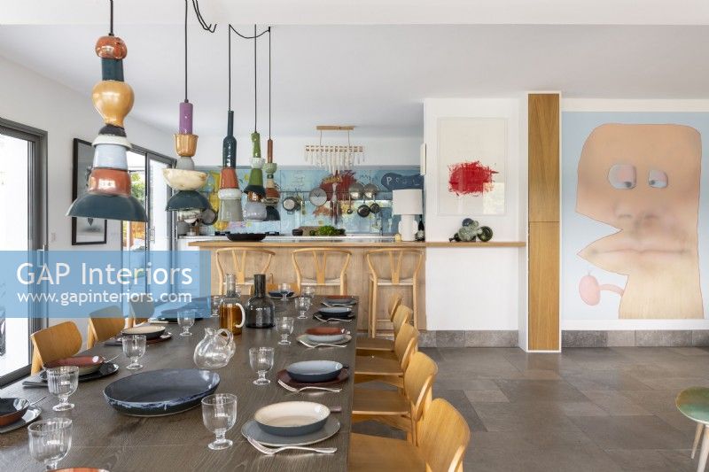 Cuisine-salle à manger moderne avec des œuvres d'art originales et des lumières en céramique