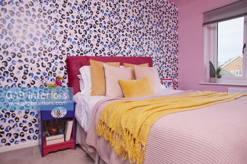 Chambre colorée avec papier peint imprimé animal et mur peint en rose.