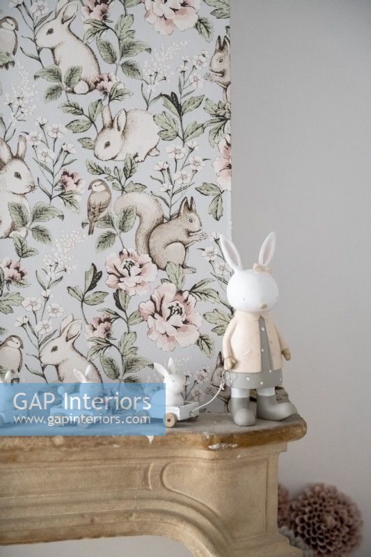 Ornement de lapin à côté de mur tapissé dans la chambre d'enfant - détail