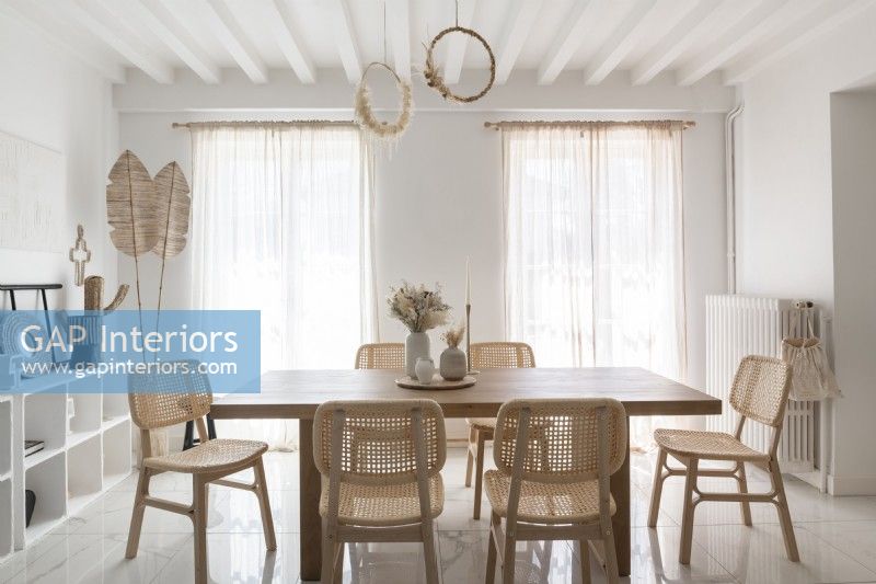 Salle à manger blanche minimale avec des meubles en bois clair