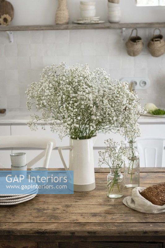 Fleurs blanches sur une table en bois dans une cuisine de campagne
