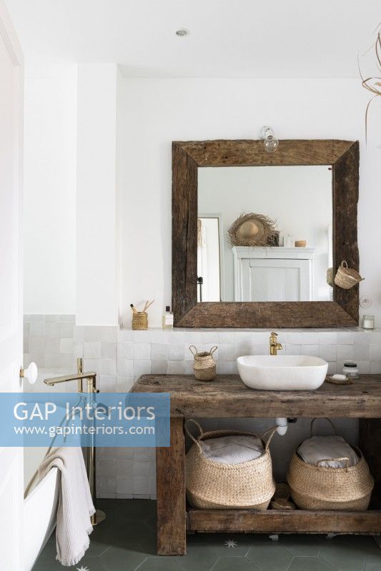 Unité en bois rustique et miroir dans la salle de bains de pays blanc