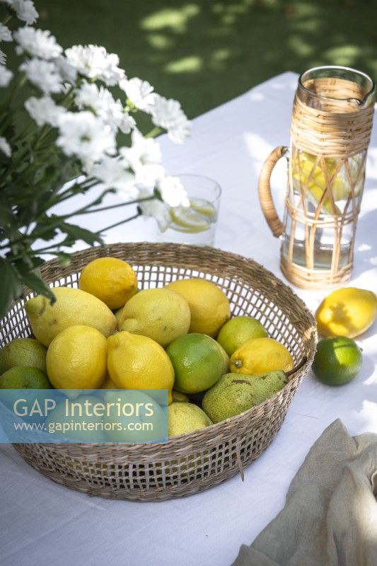 Citrons et limes dans un panier sur une table à manger extérieure