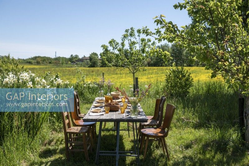 Table à manger en plein air dans le jardin avec vue sur la campagne