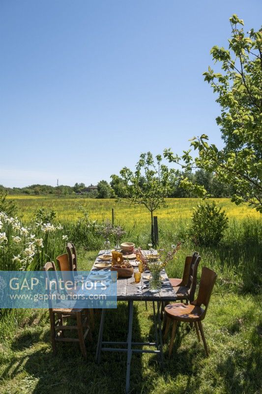 Table à manger en plein air dans un jardin de campagne avec vue panoramique