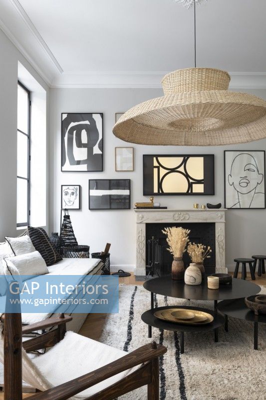 Large lampshade and display of artwork around fireplace in living room