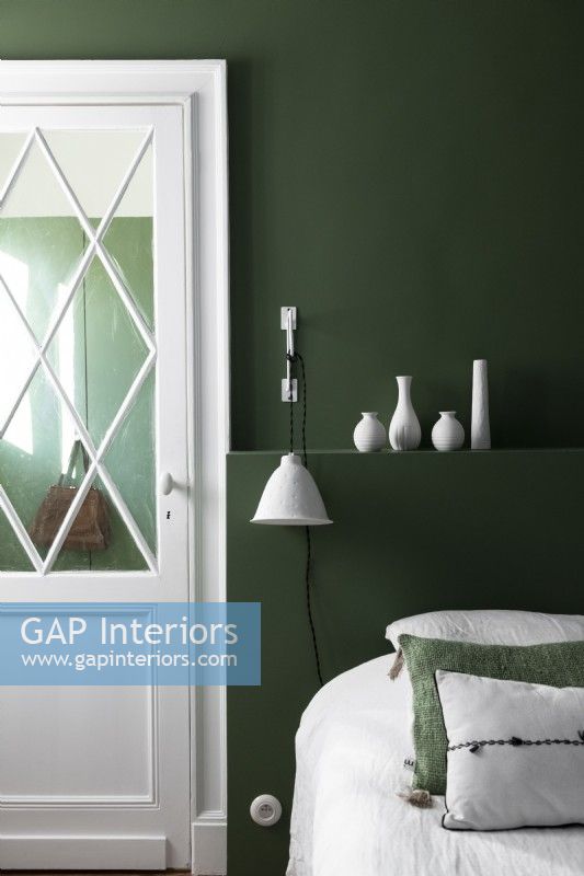 Chambre moderne verte et blanche avec présentoir de céramiques blanches