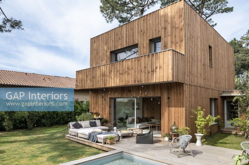 Extérieur d'une maison contemporaine en bois avec espace de vie extérieur