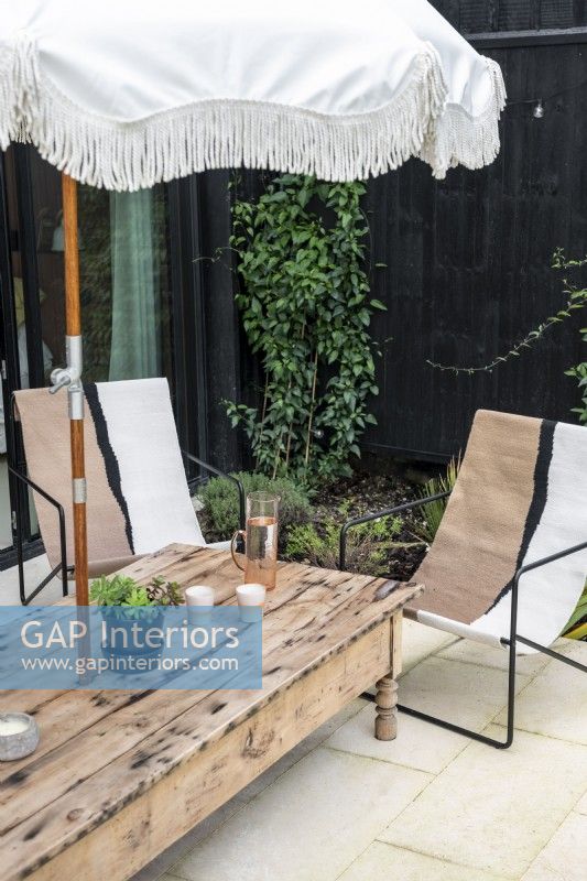 Table en bois avec parasol et chaises sur terrasse en été
