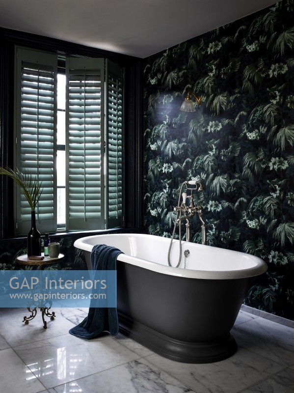 Salle de bain luxueuse avec papier peint à motifs et volets verts