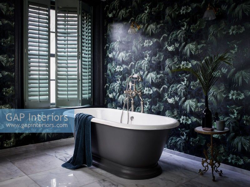 Salle de bains luxueuse avec papier peint à motifs et volets verts fissurés